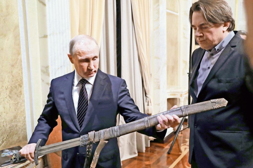 El presidente ruso, Vladimir Putin, sostiene una réplica de la espada que se usa en la película The Viking, en la reunión de ayer en Moscú con el equipo de la cinta. (MICHAEL KLIMENTYEV. EFE)