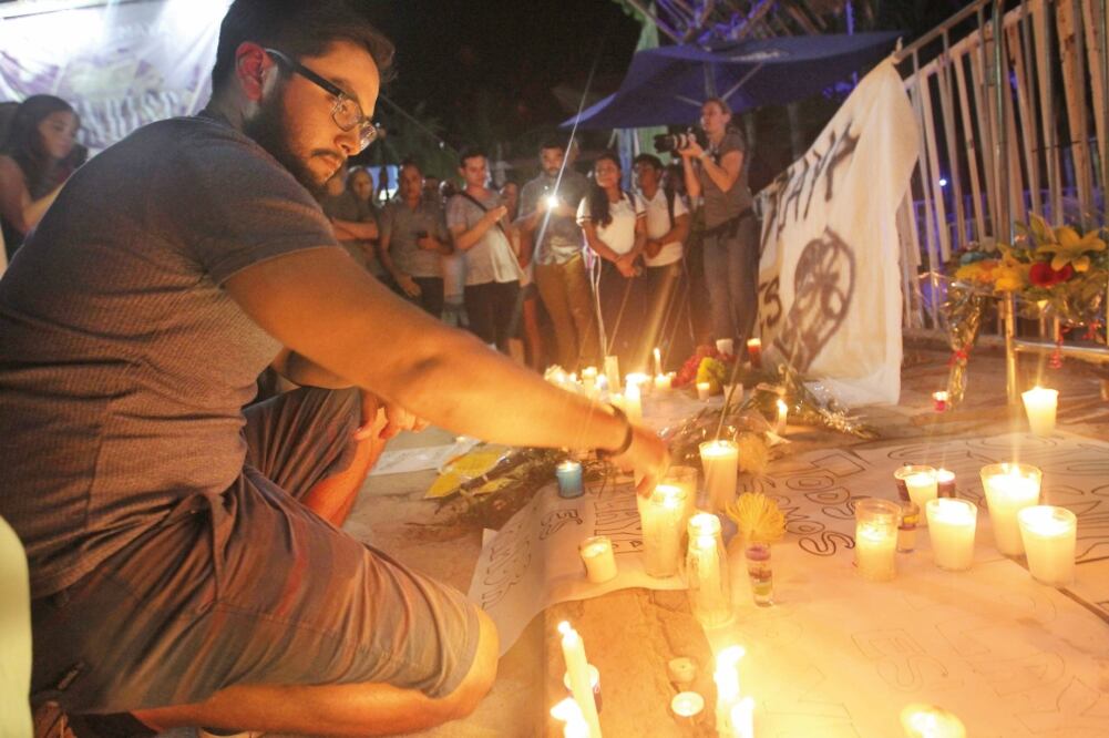 Residentes y turistas colocan veladoras y flores frente a la discoteca. La fiscalía descartó que el tiroteo se tratara de un ataque terrorista. (ALONSO CUPUL. EFE)