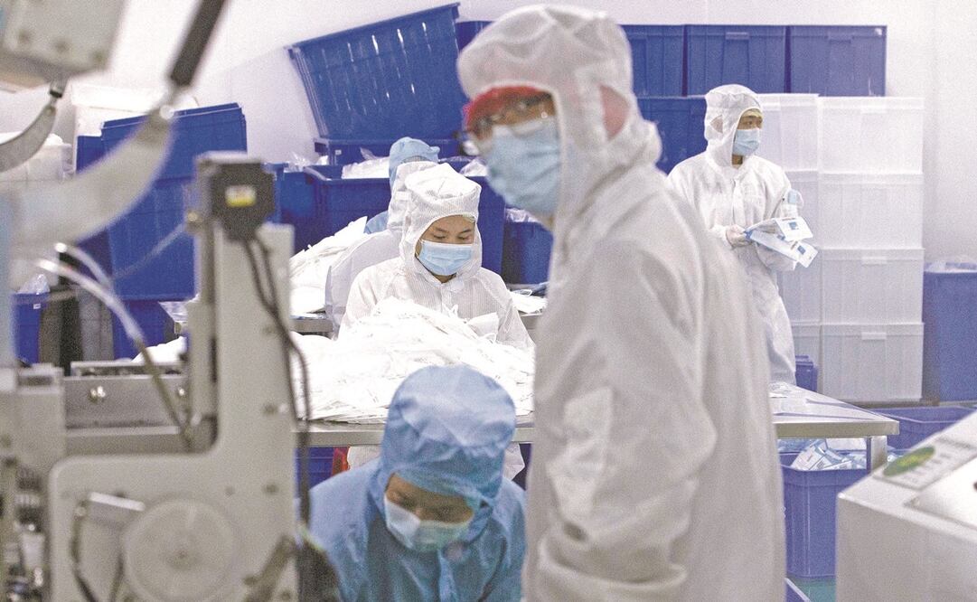 Empleados de una empresa que fabrica cubrebocas en Wuhan, China, el pasado 12 de abril. Foto: NG HAN GUAN. AP