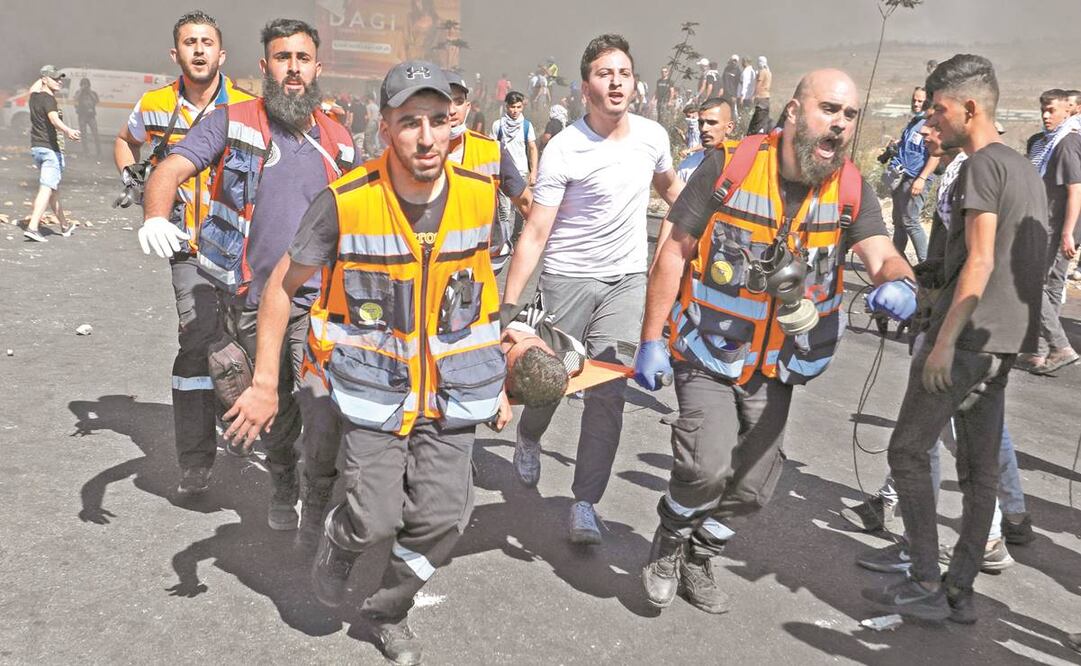 Paramédicos palestinos se llevan a un manifestante herido durante los enfrentamientos con las fuerzas de seguridad israelíes, en Cisjordania. Foto: Abbas Momani/ AFP.