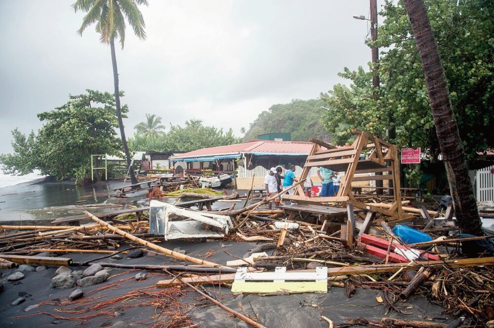 Personas revisan en los escombros de un restaurante ubicado en Le Carbet, en la isla francesa de Martinica, al sur de Dominica, luego de que la zona fuera azotada por el huracán María (LIONEL CHAMOISEAU. AFP).