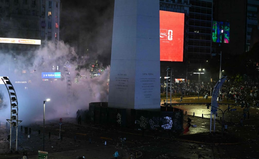Los aficionados argentinos se enfrentan a la policía antidisturbios, que se protege de la multitud, en el Obelisco tras la derrota de Argentina ante España en la final del Mundial de fútbol de la FIFA, disputada en Buenos Aires. (19/07/26) Foto: AFP