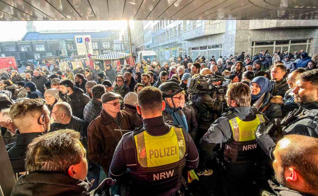 Policías y clientes bancarios preocupados se encuentran frente a una sucursal del banco Sparkasse en Gelsenkirchen, oeste de Alemania, el 30 de diciembre de 2025, tras un robo. Foto: AFP