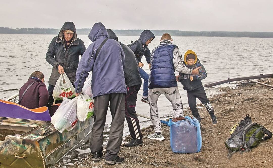 Ucranianos después de cruzar junto a un puente que fue destruido por los bombardeos, en el asentamiento de Staryi Saltiv, en Kharkiv. Foto: Sergey Kozlov/ EFE