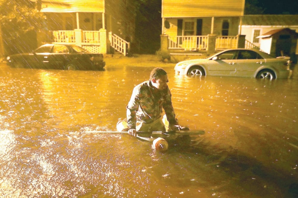 Un hombre flota en un bote improvisado en una calle inundada por el desbordamiento del río Neuse, en New Bern, Carolina del Norte, horas antes de que el huracán Florence tocara tierra en la costa sureste de Estados Unidos. Foto: CHIP SOMODEVILLA. AFP
