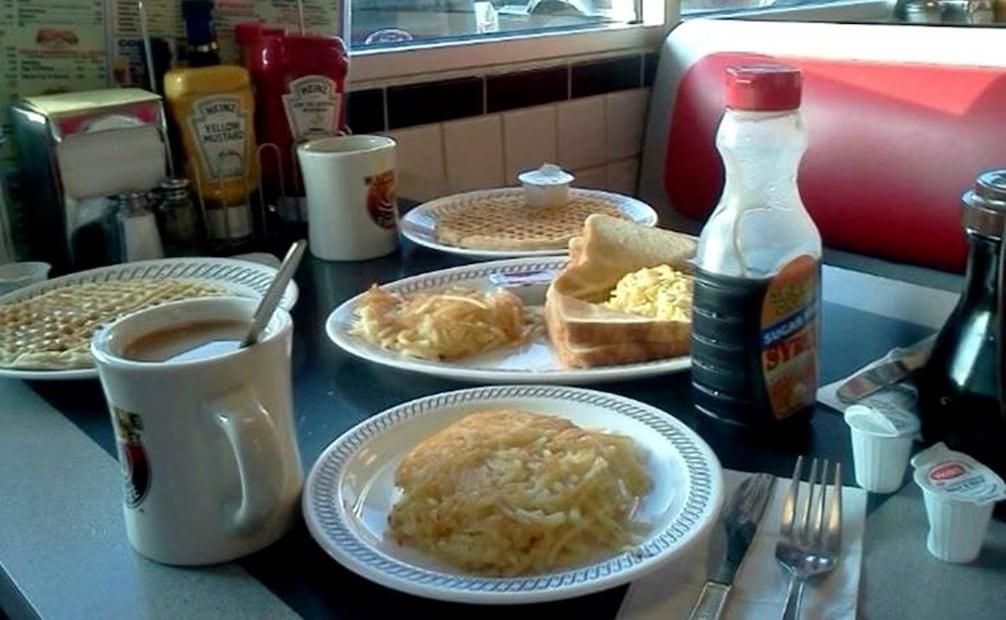 Con papas hash brown (frente), waffles (izq.) y huevos revueltos con piezas de pan recién tostado, acompañados por café y jarabe de maple, esta mesa es un desayuno típico de diner. Foto: Pinterest.