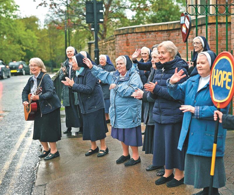 Monjas agradecen a miembros del sistema sanitario británico, donde ayer el premier Boris Johnson dijo que se dejó atrás el pico de contagios. Foto: OLI SCARFF. AFP