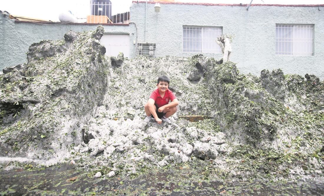 Bruno aprovechó la montaña de granizo que formaron los vecinos en la banqueta de la calle Santa Lucía, esquina Juan Cousin, en Álvaro Obregón, para escalarla y jugar sobre ella. Foto: Valente Rosas/ EL UNIVERSAL