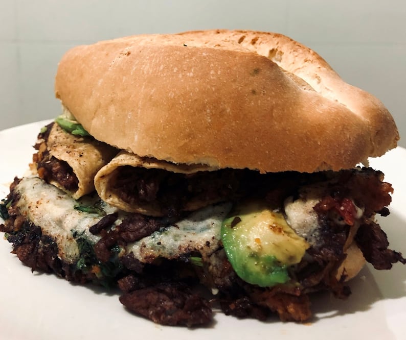 La torta está rellena de tacos de alambre con aguacate y queso, todo vegano / Foto: Malportaco