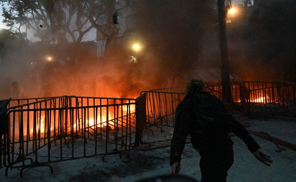 Con pintura roja, los manifestantes pintaron las vallas policiacas, por lo que respondieron rociando el contenido de extintores. Foto: AFP