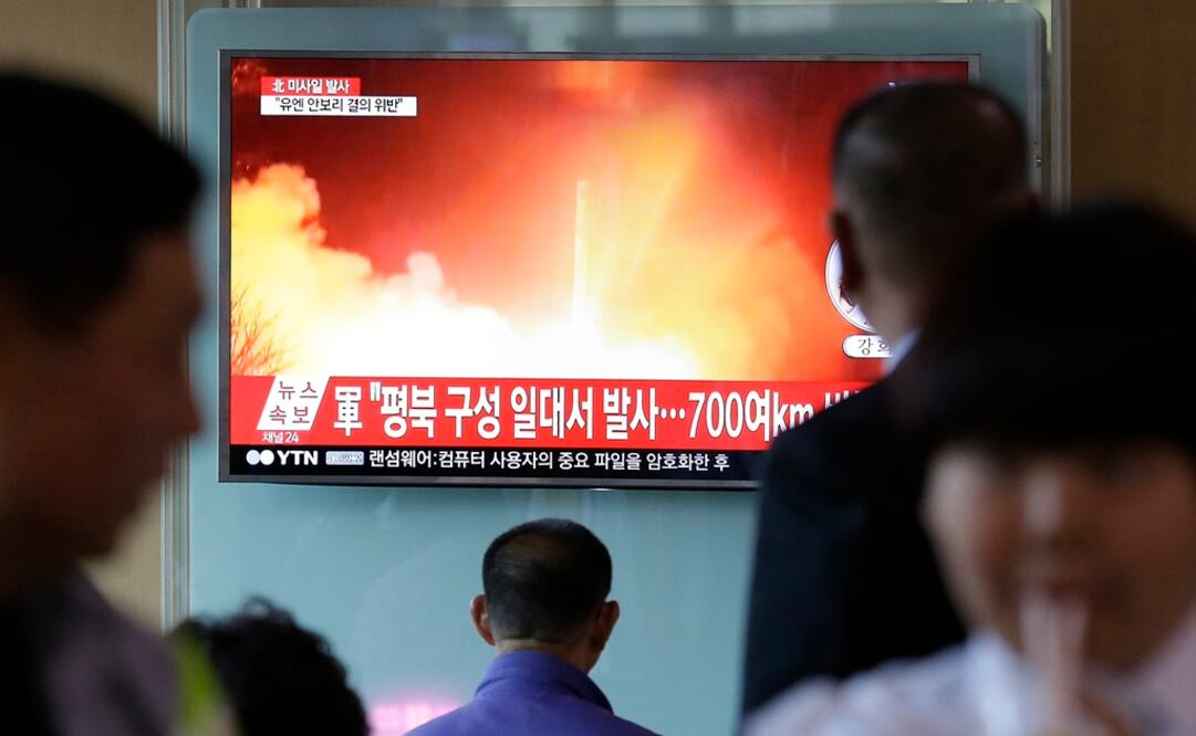 Algunas personas observan en la televisión un noticiero que muestra una imagen de archivo del lanzamiento de un misil realizado por Corea del Norte (Foto: AP)