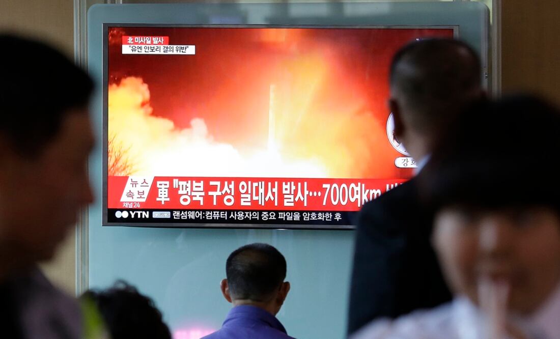 Algunas personas observan en la televisión un noticiero que muestra una imagen de archivo del lanzamiento de un misil realizado por Corea del Norte (Foto: AP)