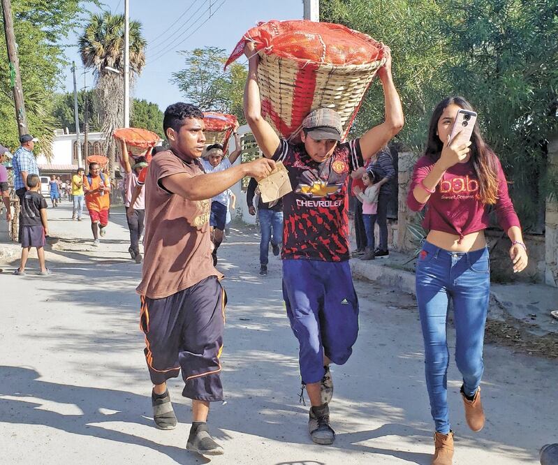 Con sus cargamentos de naranjas a cuestas, los participantes iniciaron el recorrido contando con el respaldo de sus amigos, quienes les echaban aire, les daban agua y los iban alentando durante el trayecto de 2 kilómetros. Foto/ROBERTO AGUILAR