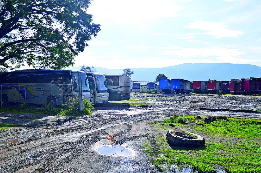 A sólo metros de la alberca de la escuela Normal Rural Raúl Isidro Burgos, lucen estacionados en filas 20 autobuses de líneas y carros repartidores de productos chatarra que han ido confiscando (DASSAEV TÉLLEZ)