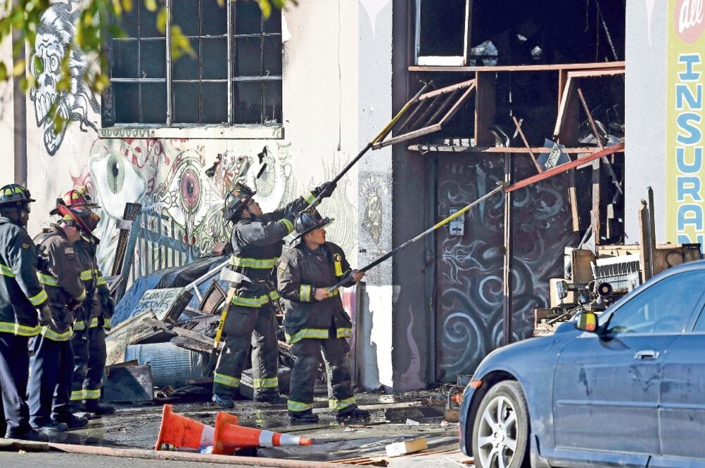 Bomberos quitan los escombros del edificio conocido como “El Barco Fantasma de Oakland”, que se incendió ayer; prevén que la cifra de muertos llegue a 40 (JOSH EDELSON. AP)