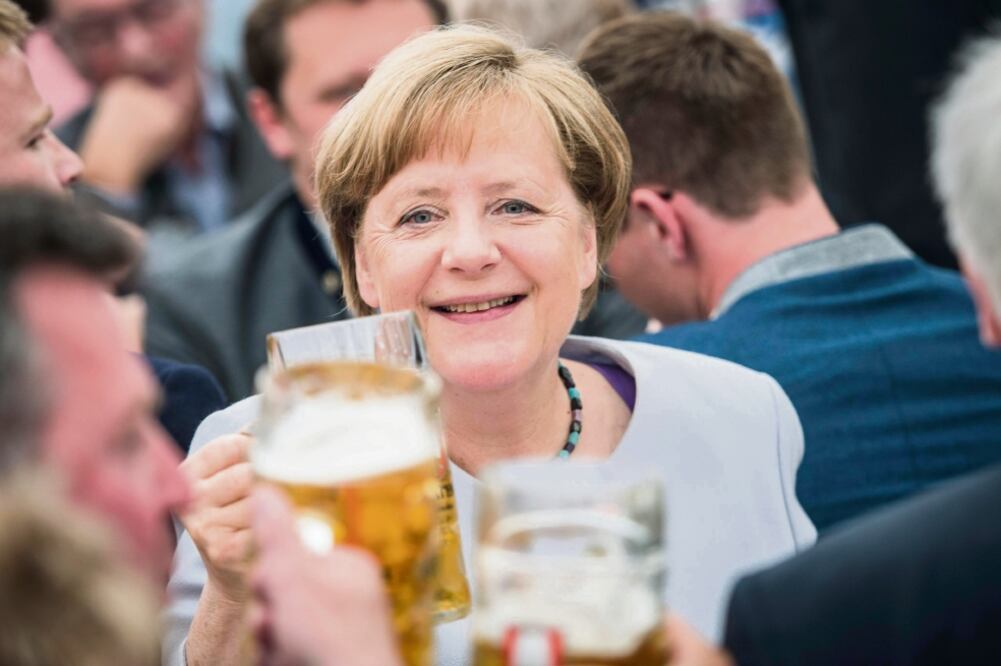 La canciller alemana, Angela Merkel, brindó con cerveza durante un evento de campaña de su partido Unión Demócrata Cristiana, el pasado 28 de mayo. (ARCHIVO EFE)