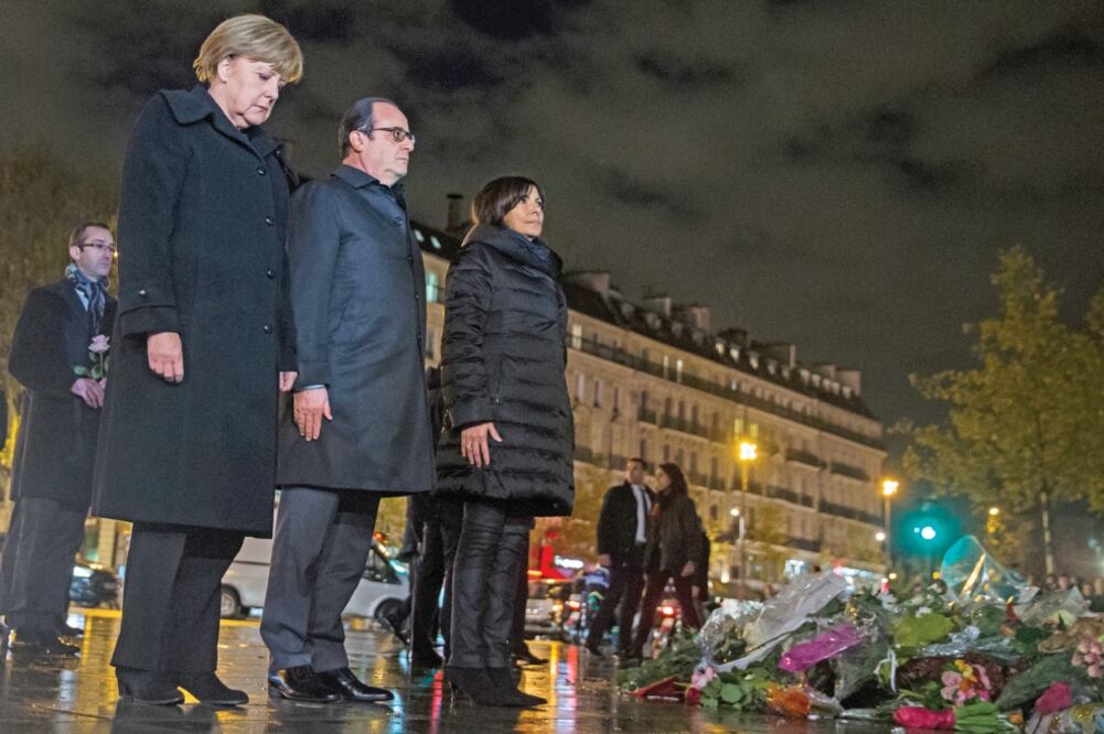 La canciller alemana, Angela Merkel; el presidente galo, François Hollande, y la alcaldesa parisina, Anne Hidalgo, homenajean a las víctimas de los ataques, en la capital francesa (ETIENNE LAURENT. AP)