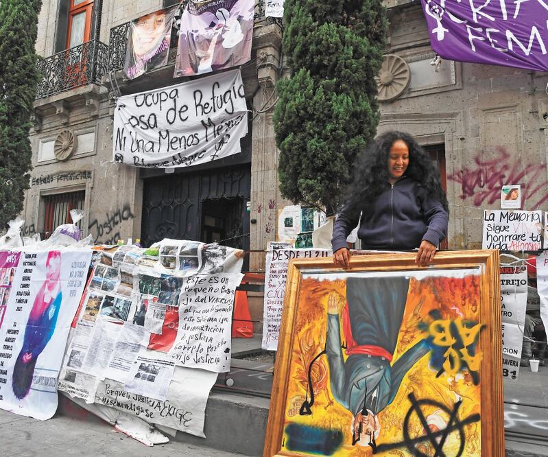 La activista y madre de una víctima de feminicido, Yesenia Zamudio, llevó los cuadros de los héroes nacionales afuera del edificio de la CNDH en el Centro. Armando Martínez. EL UNIVERSAL