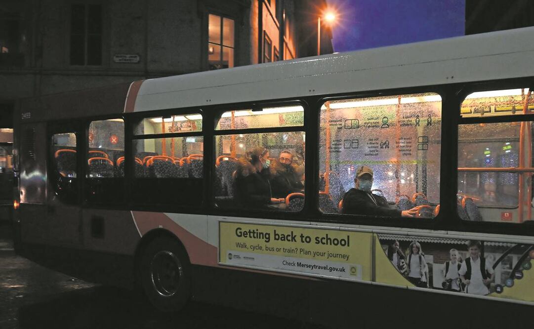 Usuarios, con cubrebocas debido a la pandemia de Covid-19, viajan en un autobús en Liverpool, noroeste de Inglaterra, en octubre de 2020. Foto: Paul ELLIS / AFP
