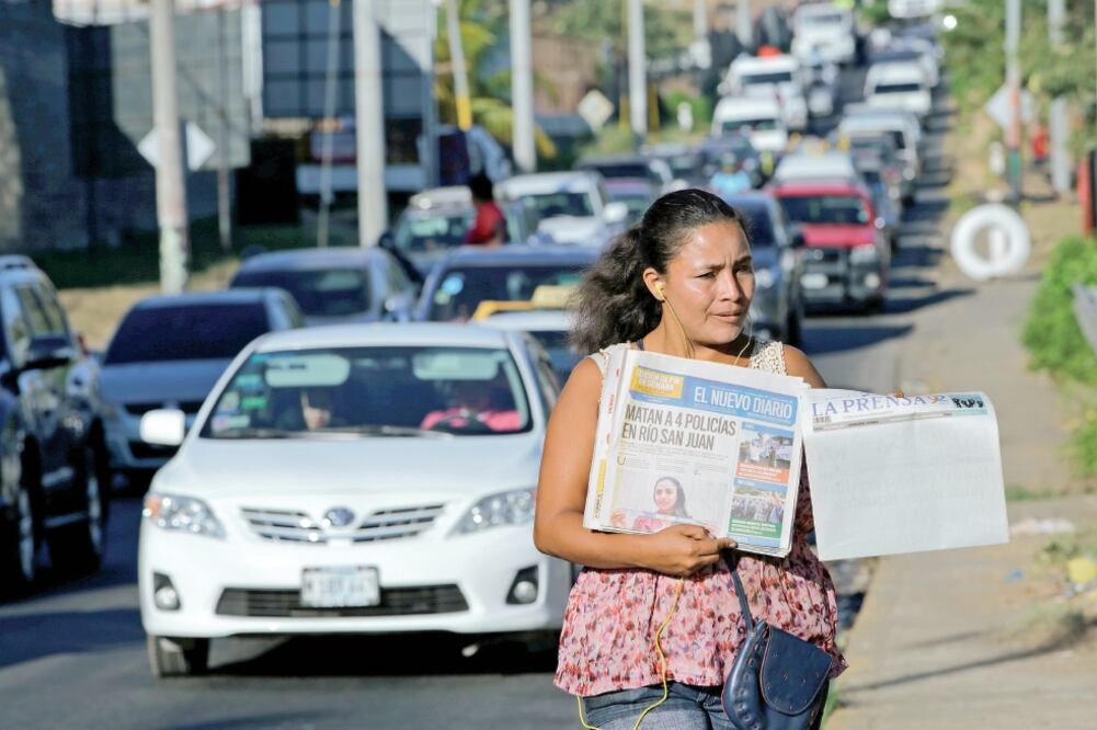 Una mujer vende La Prensa, que ayer publicó su primera plana en blanco, en protesta contra el gobierno, asegurando que mantiene retenidos desde septiembre tinta, papel y otras materias primas que son necesarias para que la publicación se imprima.(REUTERS)