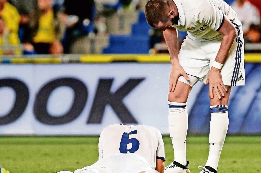 Karim Benzema, quien anotó (der.) ayudó a Nacho Fernández, tras falta (JUAN MEDINA. REUTERS)