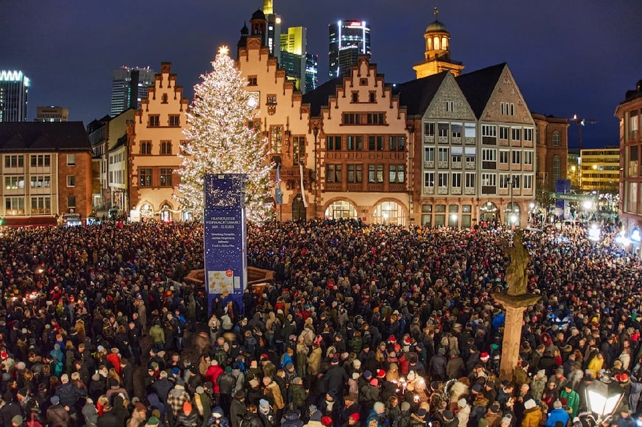 La gente se reúne en la plaza Roemerberg para asistir al repique de campanas de la ciudad en la víspera de Navidad en Frankfurt, Alemania. Foto: AP