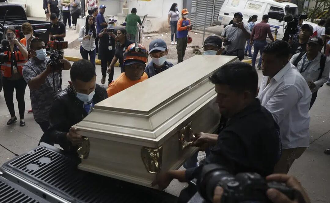 Varias personas colocan un ataúd que contiene los restos de una presa en un auto fúnebre en Tegucigalpa, Honduras, el miércoles 21 de junio de 2023. Foto: AP