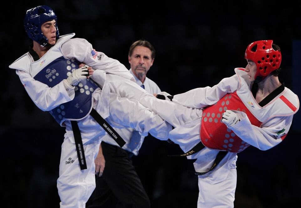 El mexicano René Lizárraga (derecha) y el estadounidense Steven López (izquierda) combaten en el último día del Campeonato Mundial de Taekwondo. FOTO/EFE