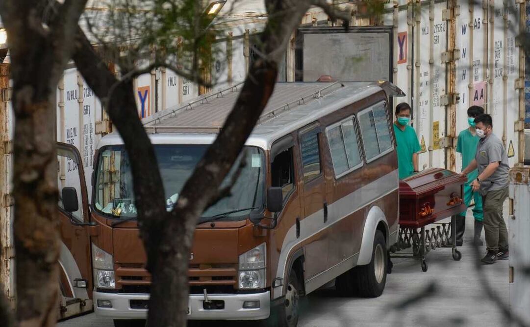 Enfermeros transportan cadáveres refrigerados. Pese a que se desconoce si el paciente falleció por Covid-19, en Hong Kong los hospitales están sobrecargados de personas contagiadas. Foto: AP