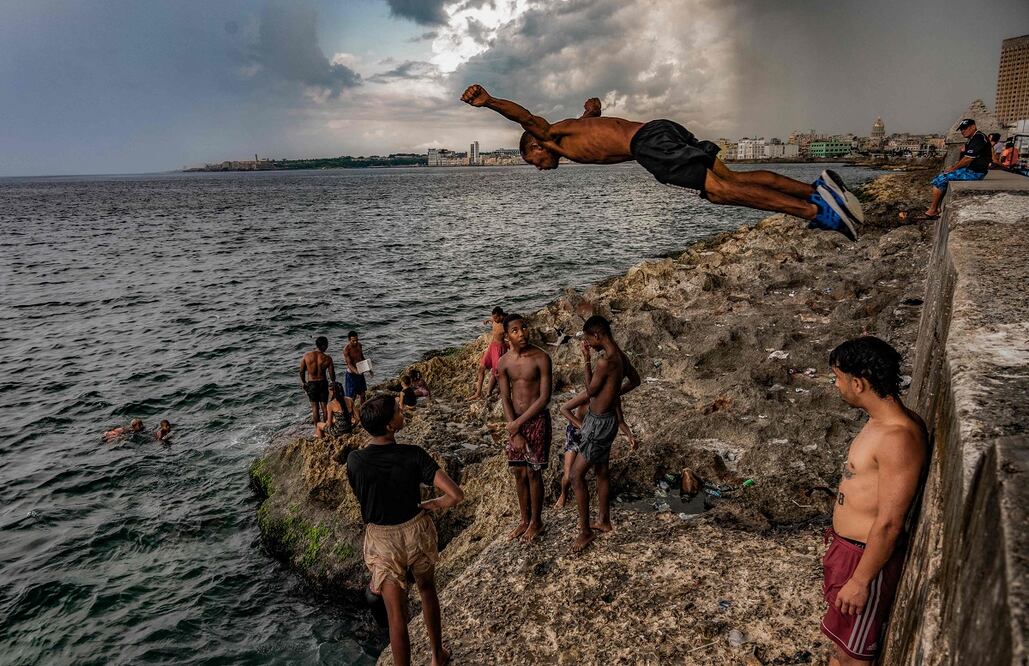Jóvenes cubanos, en el malecón de la Habana el 6 de julio de 2023. El planeta registró su día más caluroso esta semana. Foto: AFP