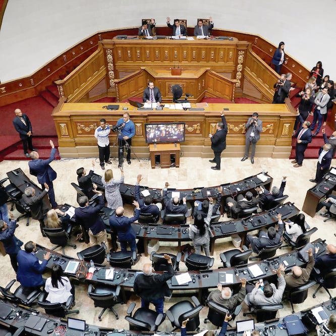 Diputados de la Asamblea Nacional de Venezuela, de mayoría opositora, votan durante la sesión de ayer en Caracas, en la que aprobaron una resolución que señala que Nicolás Maduro se apoderó ilegítimamente de la presidencia. MANAURE QUINTERO. REUTERS