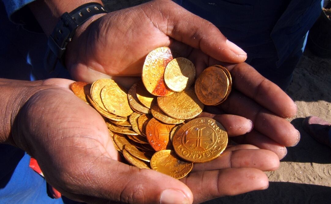 Un empleado muestra monedas de oro de un barco portugués que se hundió frente a la costa de Namibia en 1533. Foto: Dieter Noli via AP