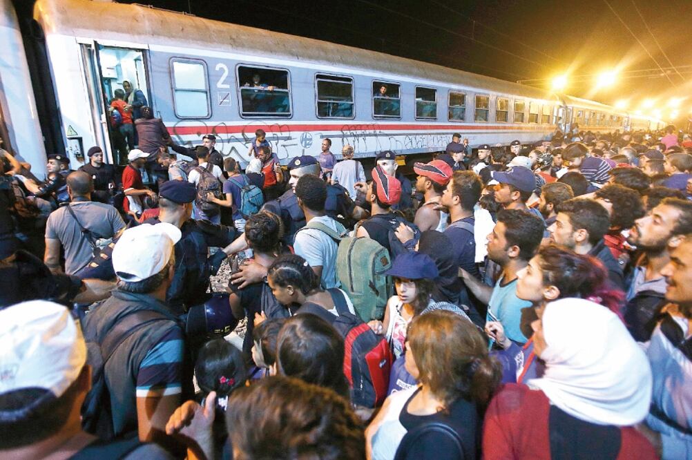 Migrantes intentan subir a un tren en la estación de Tovarnik, en Croacia. El país está permitiendo el paso de cientos de extranjeros, alegando que ya superó su capacidad de alojamiento (ANTONIO BRONIC. REUTERS)