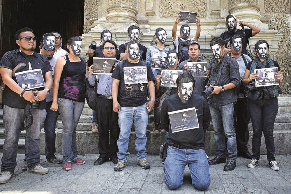 El movimiento también se extendió a Oaxaca, donde fotógrafos de prensa se colocaron máscaras con la imagen de Rubén Espinosa en señal de luto (MARIO ARTURO MARTÍNEZ. EFE)