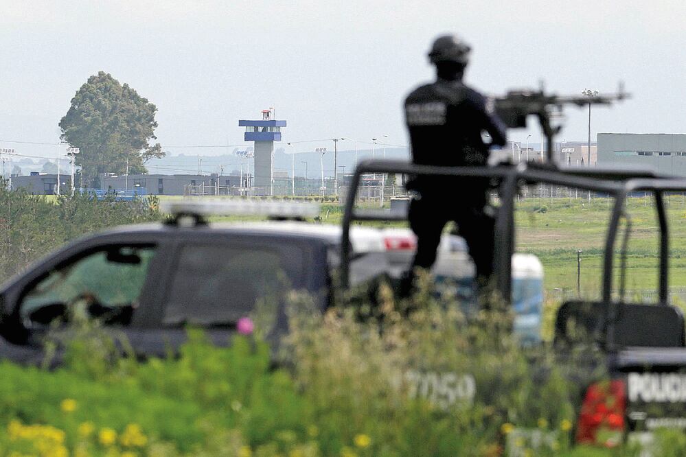 Un policía mantiene vigilancia afuera del penal del Altiplano del que se escapó el capo sinaloense la noche del sábado por un túnel, su segunda fuga de una penitenciaría de máxima seguridad en 15 años
