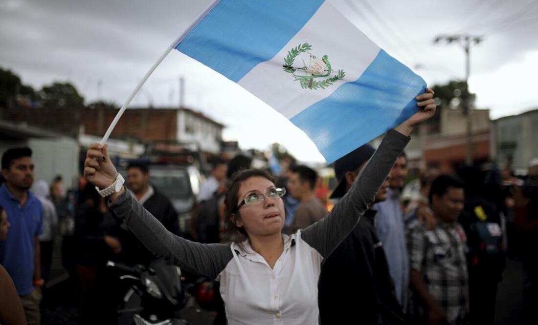 Una mujer agitando la bandera guatemalteca en las calles, en medio de la crisis política que golpea a la nación vecina. Foto: Reuters
