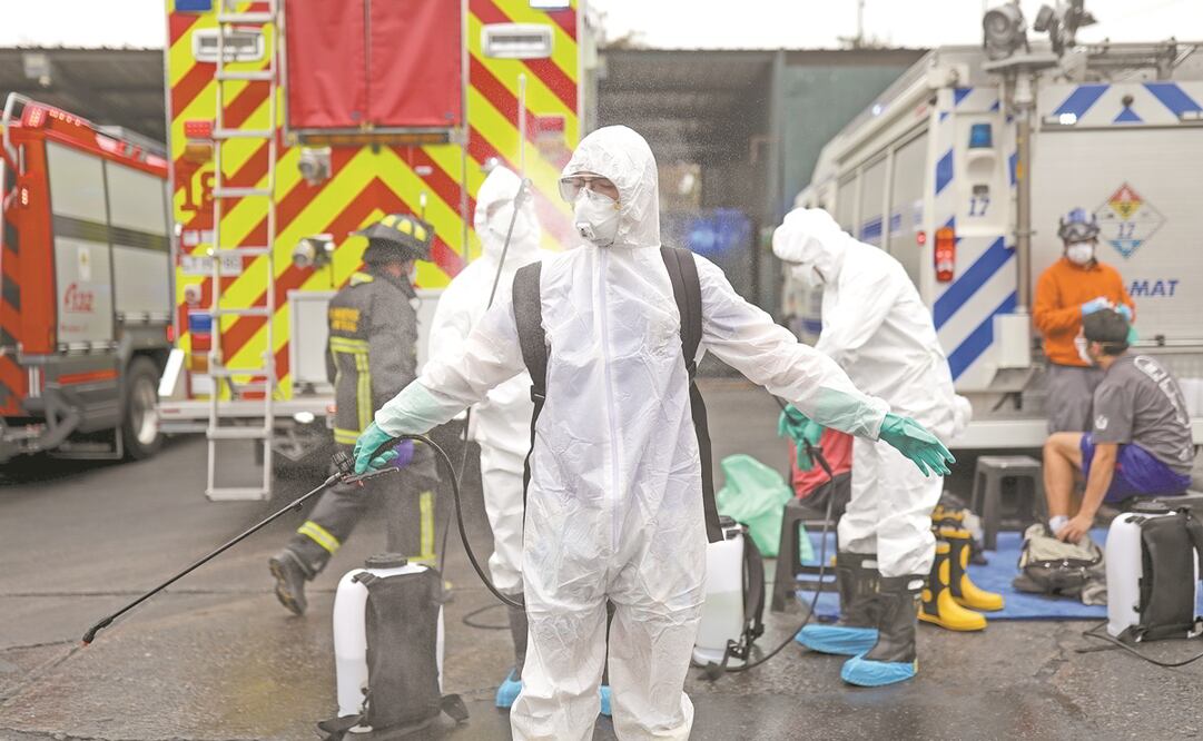 Un bombero rocía desinfectante ayer sobre su colega después de limpiar una terminal de autobuses como medida de precaución, durante una cuarentena preventiva luego del brote de la enfermedad por coronavirus, en Santiago, Chile. Foto: REUTERS