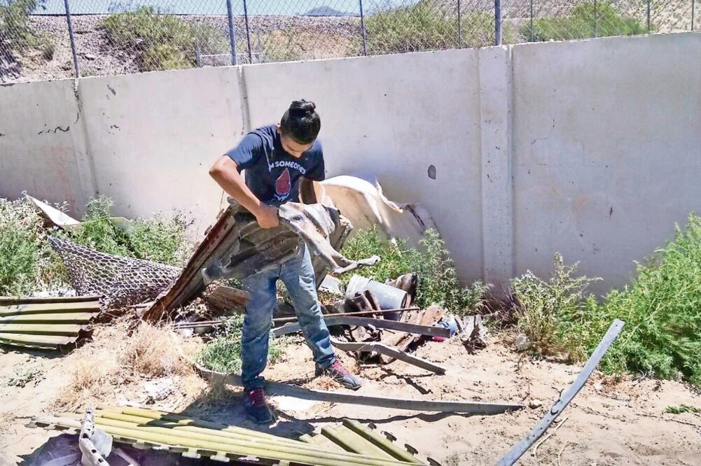 Niños y adolescentes también caminan por donde se levanta la nueva muralla y juntan varillas, láminas y tubos que cortan las cuadrillas de trabajadores (FOTOS: LUIS FIERRO. EL UNIVERSAL)