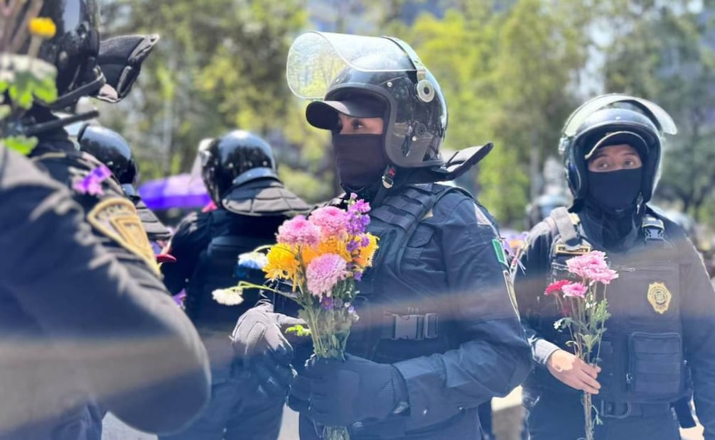 Mujeres policías de la SSC CDMX reciben flores durante la marcha del domingo 8 de marzo de 2026. Foto: Especial