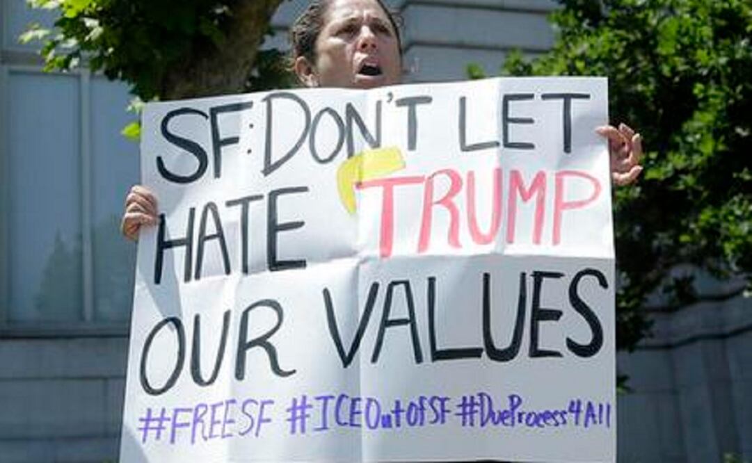 Teresa Molina holds up a sign at a rally outside of City Hall in San Francisco, where officials have long sanctioned protections for people in the country illegally. (Photo: AP)