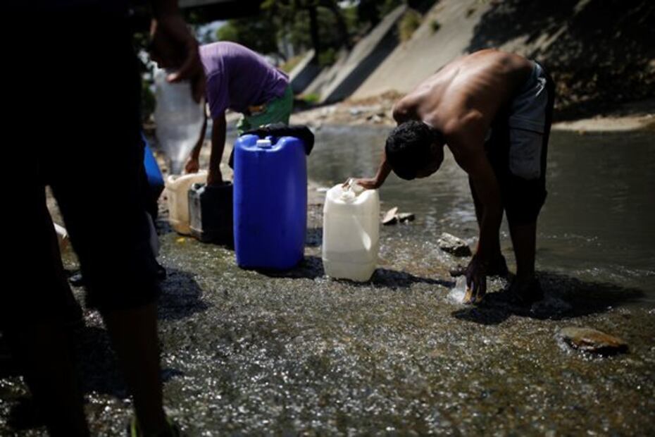 Captan largas filas para recoger agua contaminada en río de Caracas tras apagón