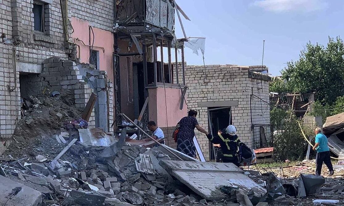 Servicios de emergencia y personas evacúan un edificio destruido después de un bombardeo en la ciudad de Voznesensk. Foto: AFP