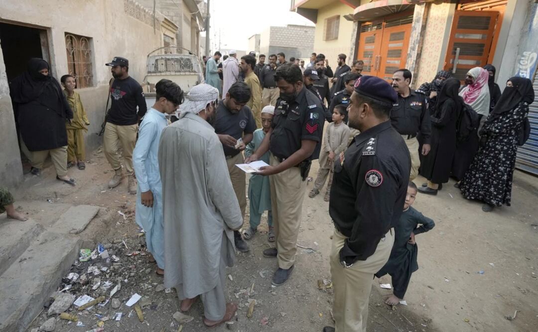 Un agente de policía comprueba la documentación de un residente durante una operación contra la inmigración ilegal, en un vecindario en Karachi, Pakistán. Foto: AP