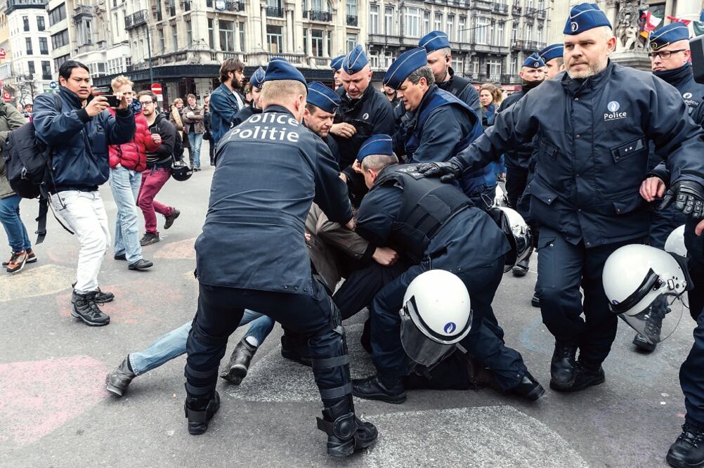 La policía detiene a un activista en la plaza de la Bolsa, en Bruselas. Decenas de personas se reunieron para expresar su rechazo al racismo. GEERT VANDEN WIJNGAERT. AP