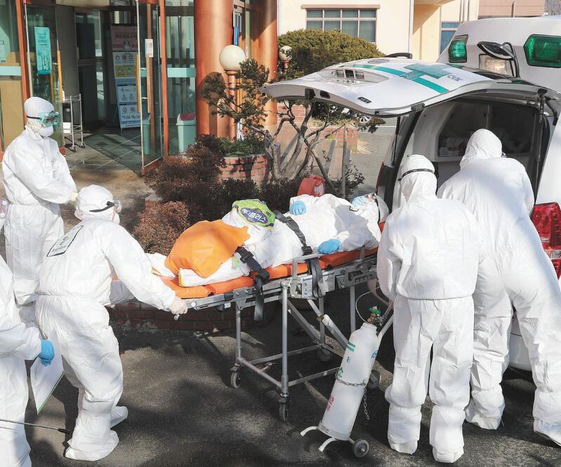 Médicos transportaron ayer a un paciente contagiado con el coronavirus del hospital Daenam, donde hay 16 infecciones que se han identificado con el Covid-19; los participantes utilizan equipo especial. Foto: AFP