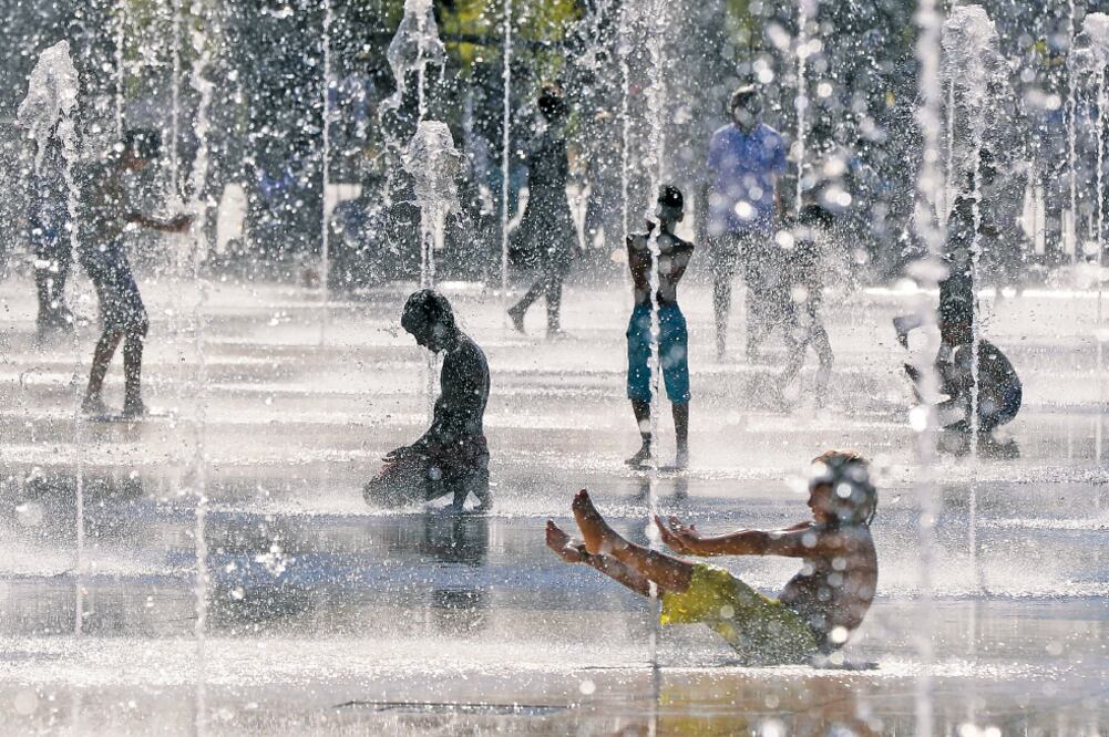 En esta foto de agosto de 2016 se muestra a niños jugando en un día cálido de verano en unas fuentes en la Riviera Francesa. (VALERY HACHE. AFP)