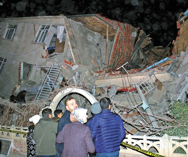Habitantes se paran afuera de un edificio colapsado después de un sismo de magnitud 6.5, en Elazig, Turquía. Foto: REUTERS