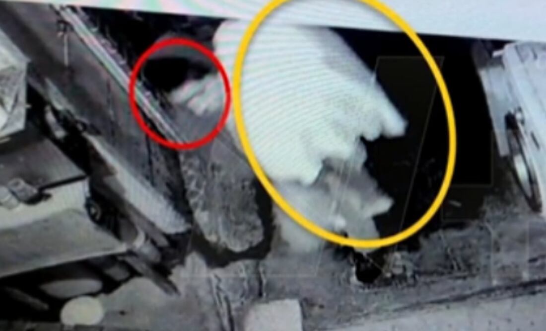 FOTO: captura tomada de Twitter @nmas/El Universal/ En la imagen, Rogelio carga el cuerpo del niño tapándolo con una sábana blanca