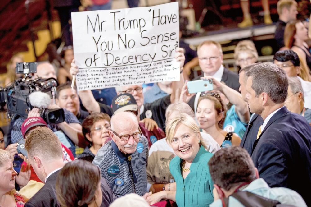 Un hombre sostiene un letrero que dice: “Sr. Trump, ¿no tiene usted sentido de la decencia, señor?” durante un evento de campaña de la candidata demócrata, Hillary Clinton, en Des Moines, Iowa (ANDREW HARNIK. AP)