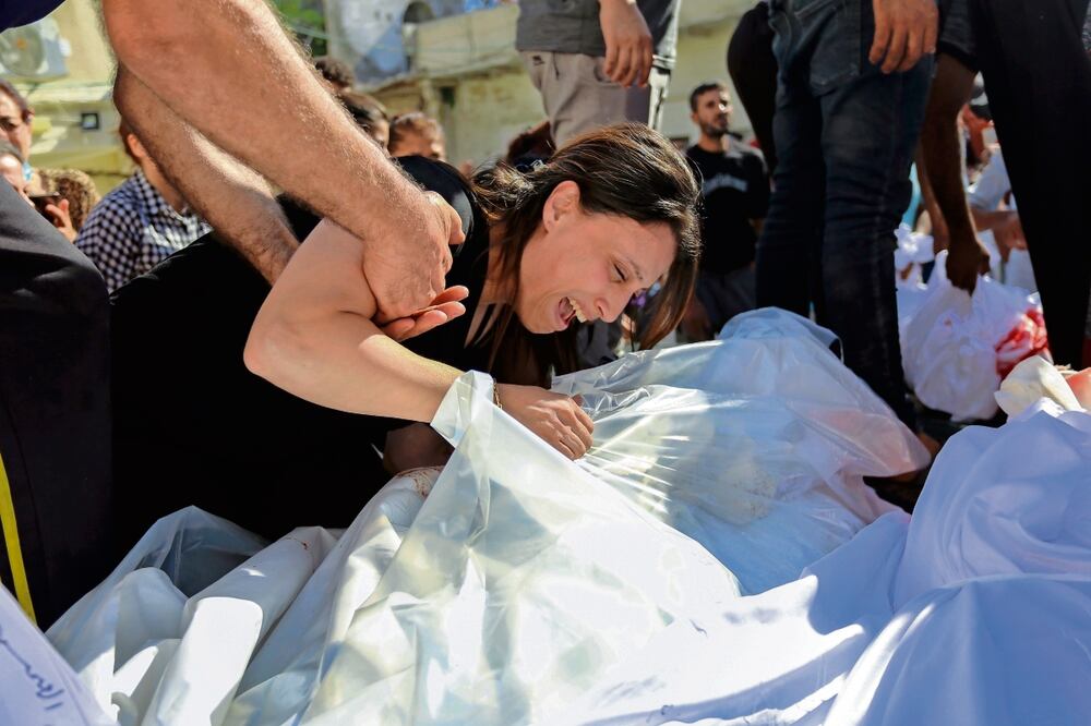 Una mujer palestina llora ante los cuerpos de sus familiares que murieron en ataques aéreos israelíes que alcanzaron una iglesia ortodoxa griega en la ciudad de Gaza. Foto: Abed Khaled / AP